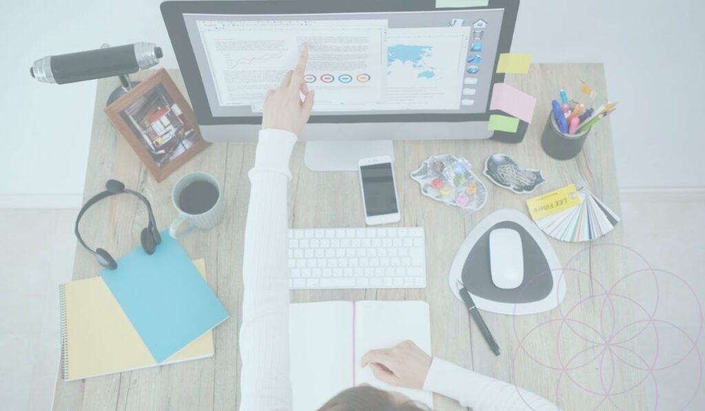 Woman sitting at a desk looking at digital products on computer