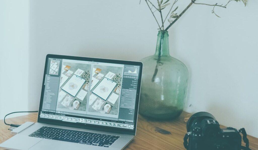 desk image with camera and computer with digital products on computer screen