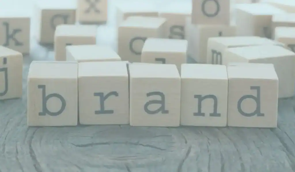 wooden blocks on tree stump with the letters "b-r-a-n-d"