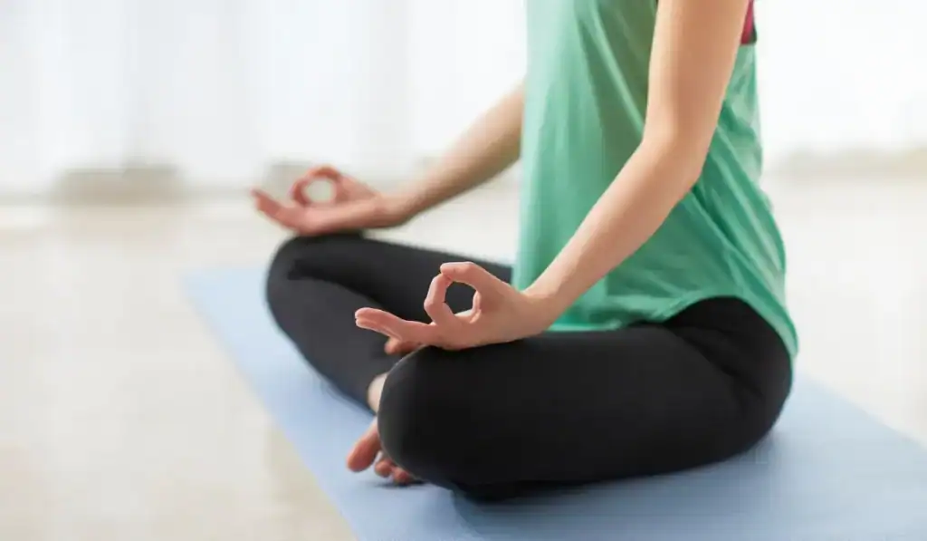 woman in green shirt sitting in yoga pose
